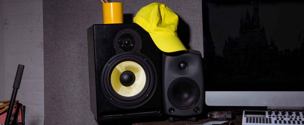 Yellow Hat Sitting on top of a Pair of Speakers