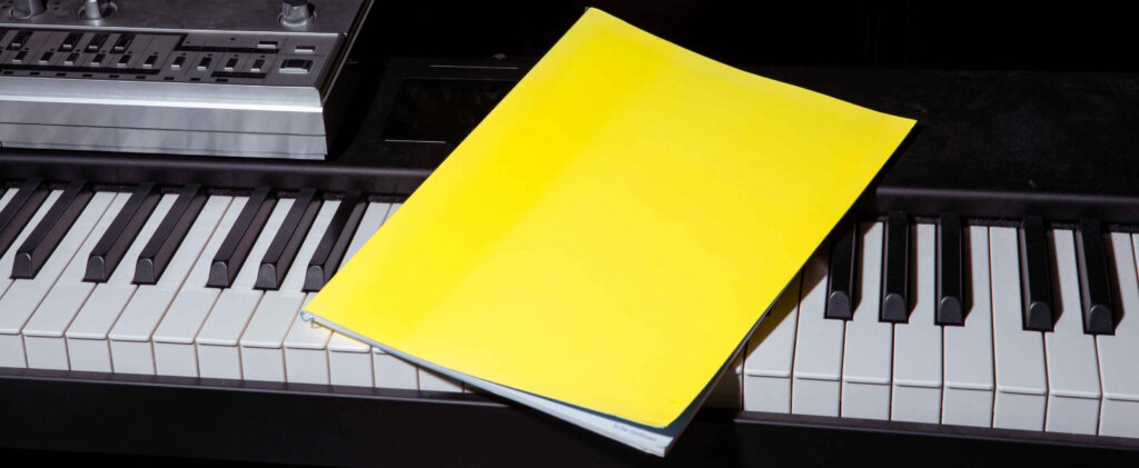 Bright Yellow Booklet Lying on an Electric Piano