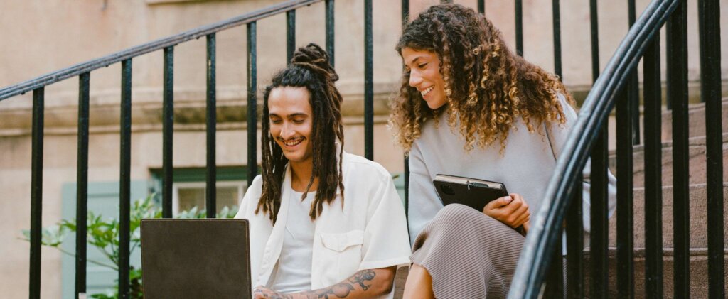 Young smiling people working on a laptop.