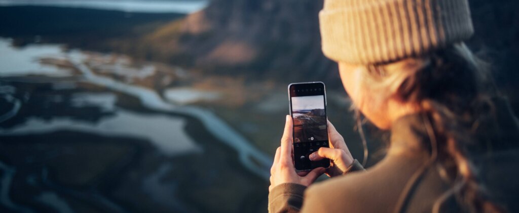 A young woman filming on her smartphone.